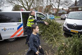Agenten helpen kinderen met inzamelen kerstbomen