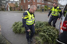Agenten helpen kinderen met inzamelen kerstbomen
