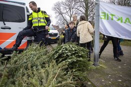Agenten helpen kinderen met inzamelen kerstbomen