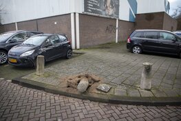 Automobiliste schampt sporthal, rijdt over paal en raakt gewond
