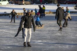 Drukte op het ijs bij de molen aan de Heussensstraat in Haarlem
