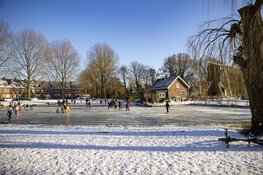 Drukte op het ijs bij de molen aan de Heussensstraat in Haarlem