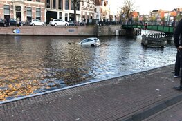 Auto drijft in Spaarne in Haarlem
