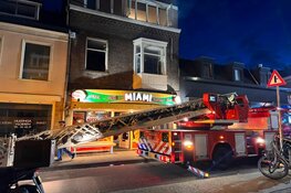 Brandweer redt twee mensen uit dakgoot bij brand