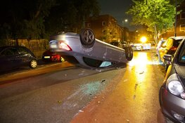 Auto ramt geparkeerd voertuig en vliegt over de kop in Haarlem